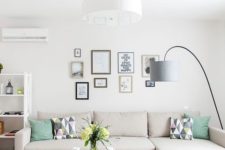 06 a small living room with a statement chandelier and a floor lamp that is used as a task light