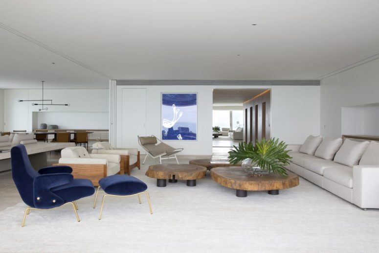 A blue statement artwork and a navy chair and footrest hint on the seaside location of the apartment A blue statement artwork and a navy chair and footrest hint on the seaside location of the apartment