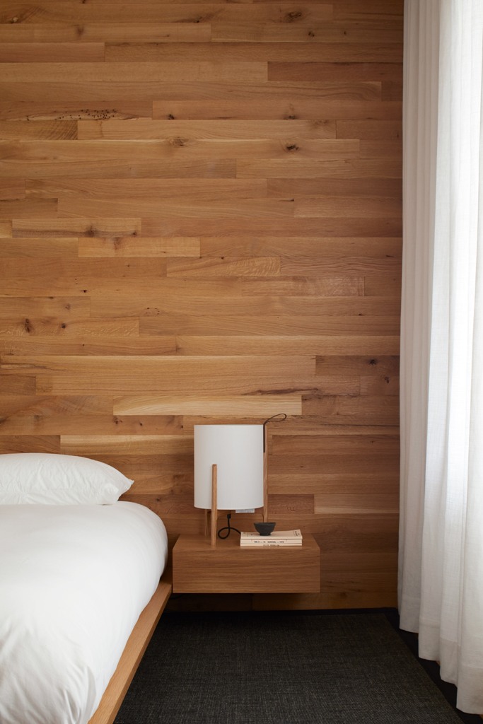 a stylish wood wall in a bedroom The master bedroom is done with a statement wall of wood and floating nightstands plus a floating bed, it's all neutral