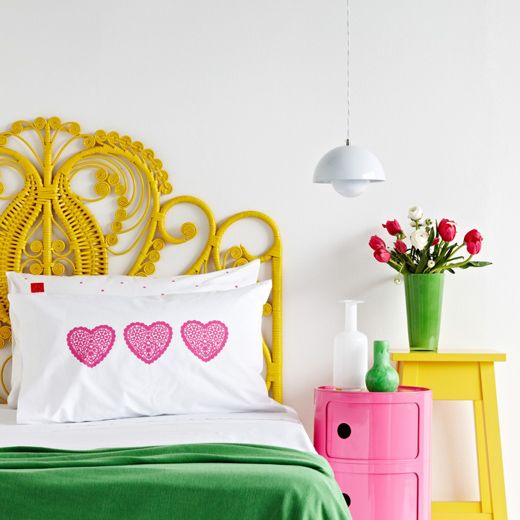 a creative woven yellow headboard matches the bright color scheme of the bedroom