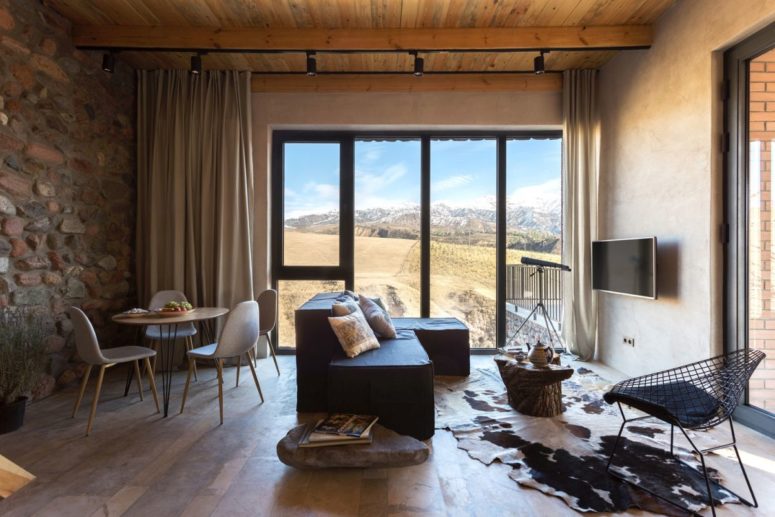 The living and dining space feature amazing views, an animal skin rug, contemporary furniture