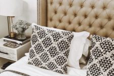 a neutral tufted wingback headboard with decorative nail trim is a chic and timeless idea that never goes out of style