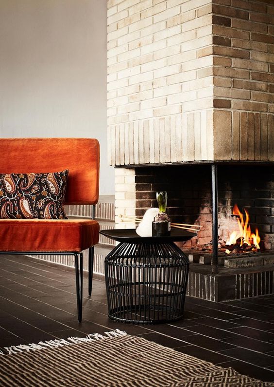 a bold orange velvet chair with hairpin legs brings mid-century modern chic and a fall touch to the space