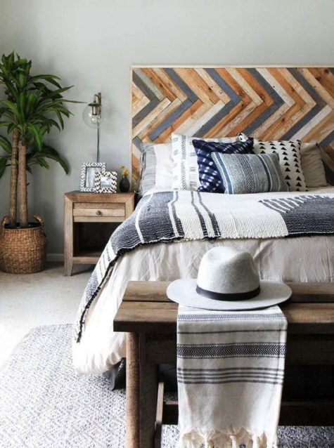 a bright wooden headboard done with a pattern and muted colors to add a relaxed boho feel to the bedroom