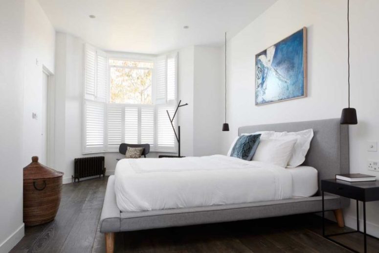 The master bedroom resembles the living room, there's a comfy upholstered bed, a shuttered window and a statement artwork The master bedroom resembles the living room, there's a comfy upholstered bed, a shuttered window and a statement artwork