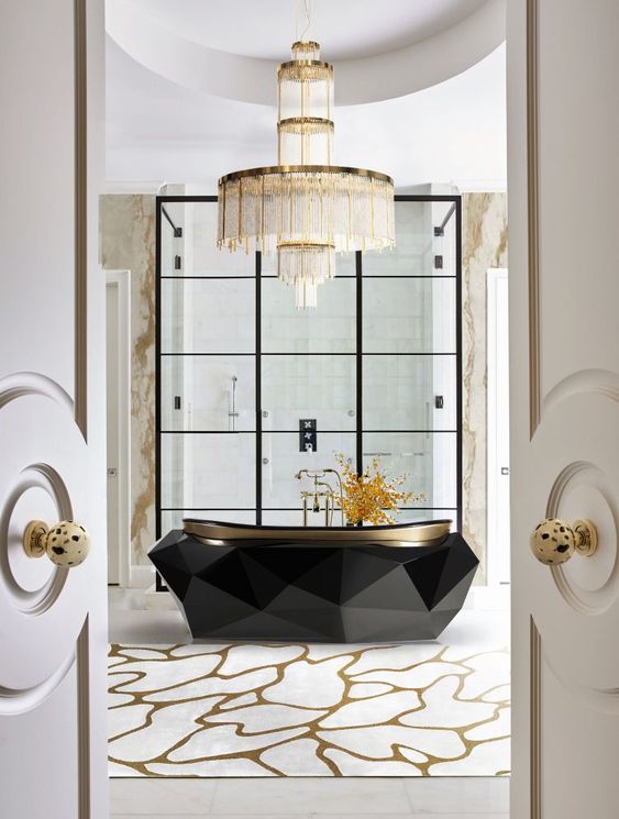 a jaw dropping bathtub with a faceted design and a statement chandelier over it for a bold combo