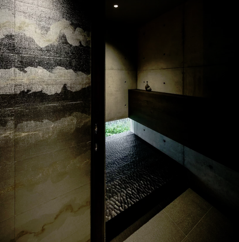 Natural stone and textural tiles plus dark wood make the shower space spa-like