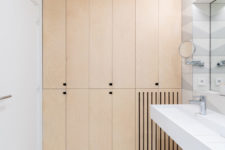 12 The bathroom continues the decor of the apartment with sleek plywood cabinets and neutral tiles