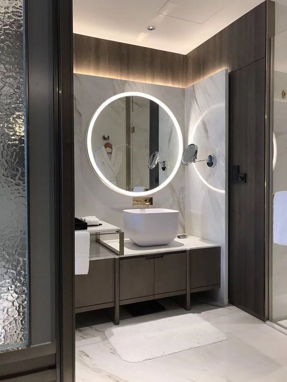 a minimalist bathroom with built in lights in the mirror and wall around the vanity looks super chic and amazing
