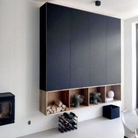 a large navy storage wall-mounted unit built of several IKEA Metod cabinets and some open storage boxes underneath