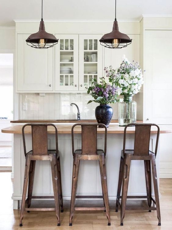 amazing aged metal pendant lamps that echo with the stools and create a mood in the kitchen