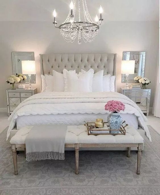 a neutral wingback tufted upholstery headboard and a matching upholstered bench for a chic and glam space