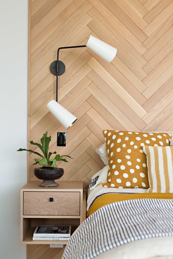 a stylish wooden headboard done with a herringbone pattern and with floating nightstands attached will make the bedroom cozier
