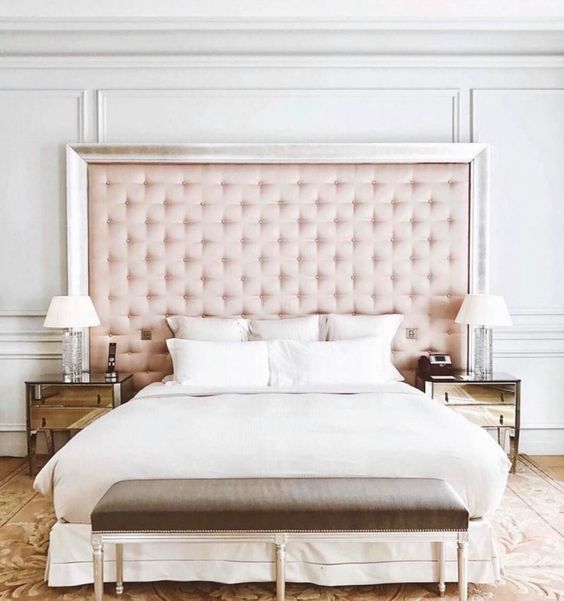 a blush tufted headboard with a shiny frame is a perfect match for a glam inspired bedroom liek this one