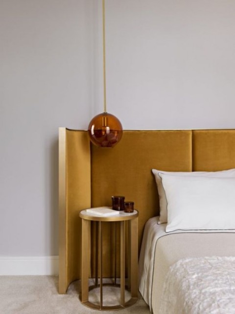 a curved mustard velvet headboard in a gold frame is a stylish and chic option for any sleeping space