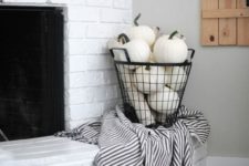 18 a wire basket filled with white pumpkins and with a black and white blanket will glam up your space