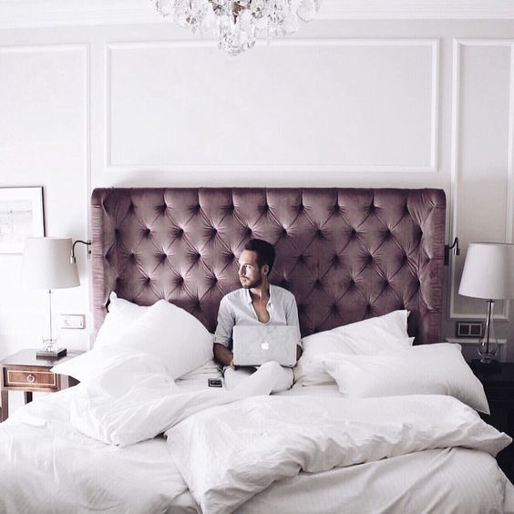 a dusty pink tufted wingback headboard brings a muted color touch and chic to the space