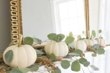 22 a fall mantel dcorated with white pumpkins, eucalyptus and with a statement gold ramed mirror