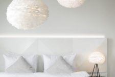 22 large fluffy feather pendant lamps and an echoing table one create an airy feeling in the bedroom