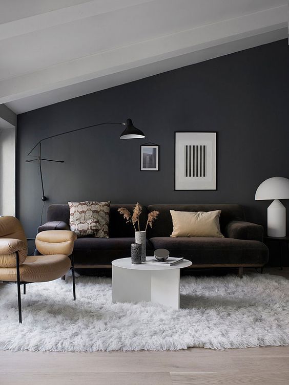 a black wall sconce matches the style and colors of this living room providing some cozy light