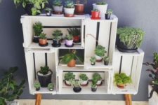 23 a simple and chic garden made of crates and wooden legs is a cute idea of an open storage unit