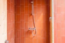 26 a shower space accented with brigth coral tiles to make it stand out in the bathroom