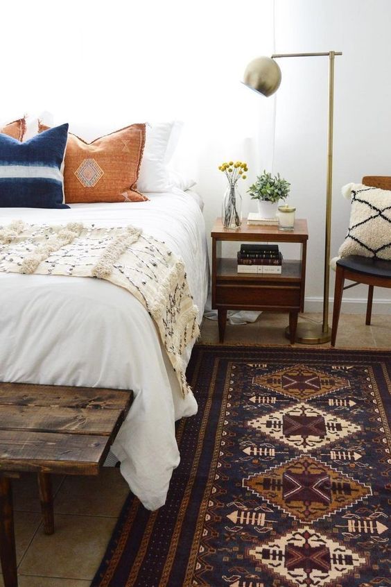 various textiles with fringe, wood, a metal lamp and much greenery for a textural look