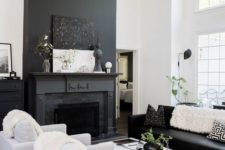 a Nordic living room with a black fireplace, black and white furniture, a black fan and a white coffee table