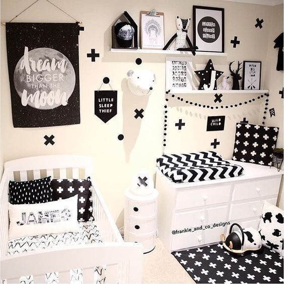a bold monochromatic nursery with open shelving, a changing table and a crib plus lots of prints everywhere