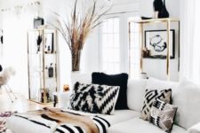 a fantastic black and white living room with stripes and chevrons, gilded touches for a glam feel and a dried herb arrangement