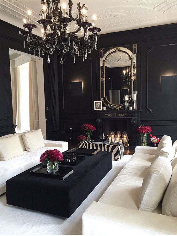 a gorgeous and luxurious living room in black with creamy furniture and a rug to refresh it and touches of metallics and glass to make it more glam