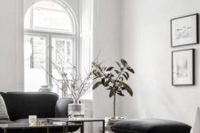 a refined Parisian-inspired living room with chic black furniture, a black chandelier and a gallery wall