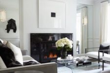 a refined contemporary living room with a sleek black fireplace, a sheer acrylic table and some black touches for drama