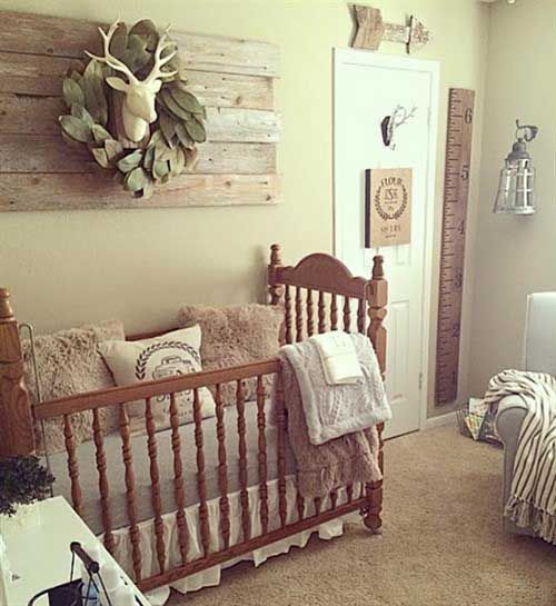 a small vintage farmhouse nursery with a reclaimed wood artwork, a vintage crib, cozy rugs and furniture