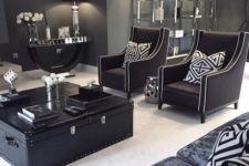 a stylish living room done in mostly black and graphite grey with touches of white to refresh the space and vintage furniture