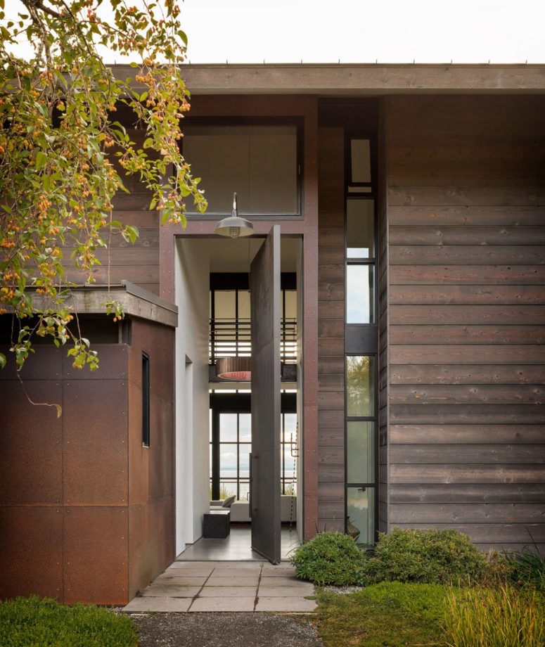 Its exterior done with dark wood and aged metal blends the landscape, while lots of windows bring much light and views in