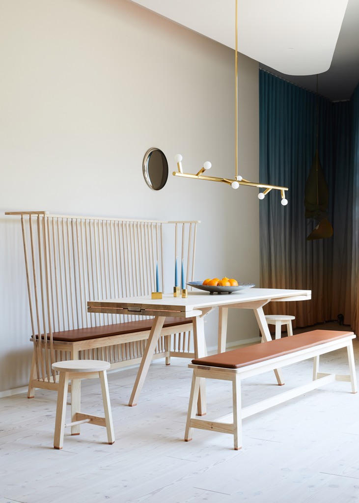 The dining space is done with a wooden table and some benches - with a back and no back, there's a catchy gold chandelier