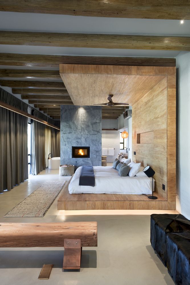 The master bedroom is united with the master bathroom, they are only divided with a fireplace, and wood and stone give a luxurious touch to the spaces