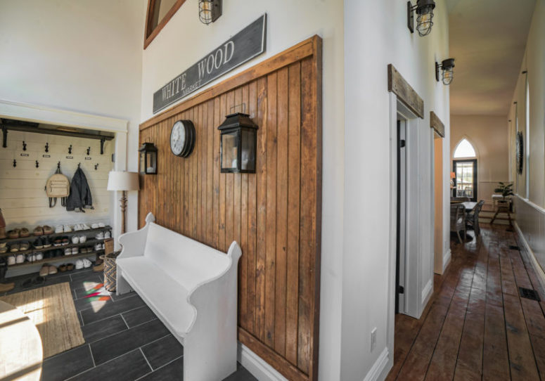 The wooden bench, built-in shelves and a stained wood wall make the entryway super cozy and functional