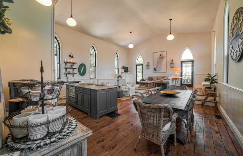 The kitchen and dining space are united, with stained and grey wooden furniture and comfy rattan chairs - a wonderful space to have a meal