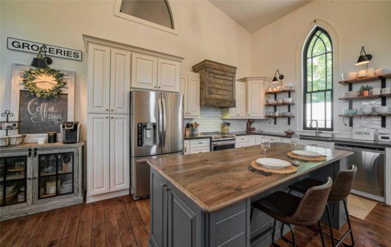 The kitchen is done with much reclaimed and stained wood, white subway tiles and some pretty signs - everything screams farmhouse here
