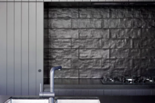 a moody kitchen backsplash made of textural tiles
