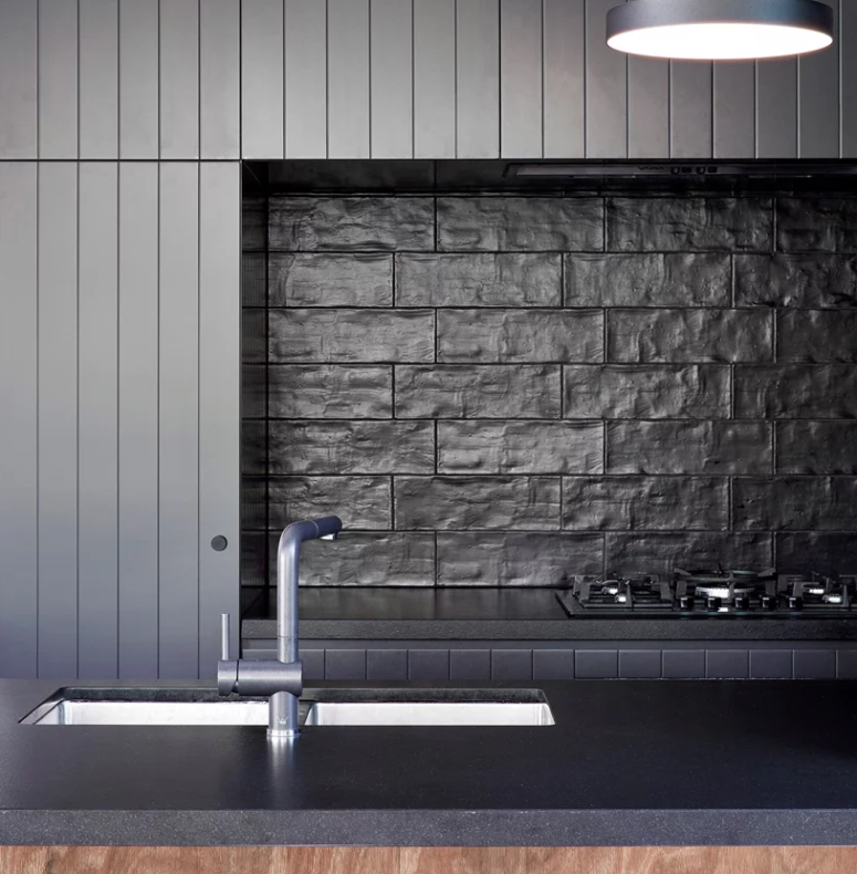 a moody kitchen backsplash made of textural tiles The kitchen will remind you of Japanese minimalism and the textural tiles on the backsplash give interest to it