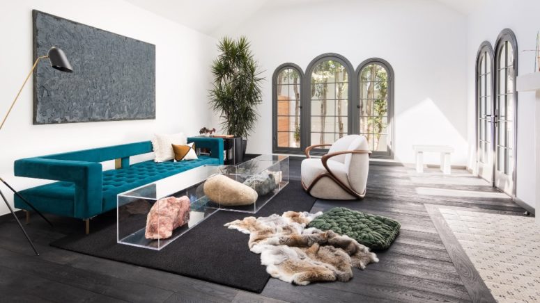 The living room is done with catchy and sculptural modern furniture plus acrylic tables with rocks inside