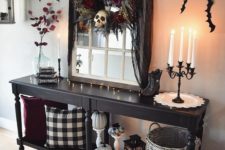 06 a Halloween entryway console with pumpkins, bats on the wall and a darkflorla wreath with a skull for a moody touch