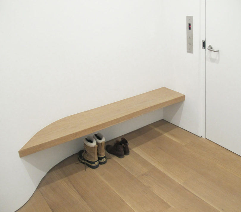 The entryway features just a buiilt in bench and curves to make the space more interesting