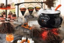 10 a stylish Halloween food and drink station with a cauldron with drinks, a broom with witch hats for food serving, drinks and sweets that match