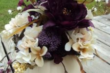 11 a white pumpkin centerpiece with neutral and deep purple flowers, berries and branches for Halloween