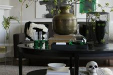 12 pretty Halloween coffee table styling with a skull, an owl in a cage and some greenery branches with a blackbird