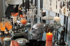 20 a refined Halloween drink bar with black and white candles, black glasses, touches of orange and sparkly silver details